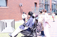 車いすの参加者ととびラーで屋外彫刻を鑑賞する様子